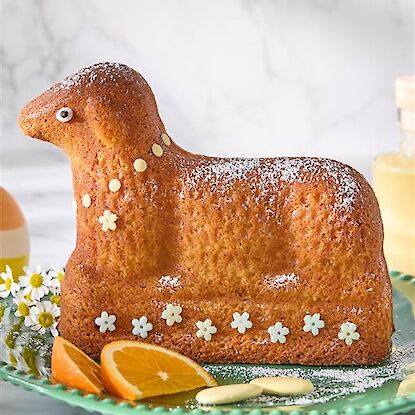 Gebackenes Osterlamm mit Zuckerdekor und Orangenscheiben auf einer Servierplatte