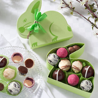 Gr&uuml;ne Pralinenschachtel in Hasenform mit Schleife, gef&uuml;llt mit gemischten Schokoladenpralinen als Osterpr&auml;sent.