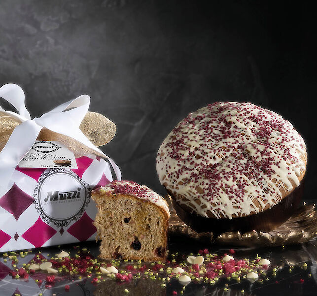 G&acirc;teau italien artisanal napp&eacute; de gla&ccedil;age blanc et de fruits rouges, pr&eacute;sent&eacute; tranch&eacute; avec un emballage cadeau d&eacute;coratif.