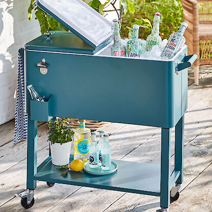 Getr&auml;nkek&uuml;hler auf Rollen mit Eis und Flaschen auf Terrasse, mobiler Outdoor-K&uuml;hlwagen