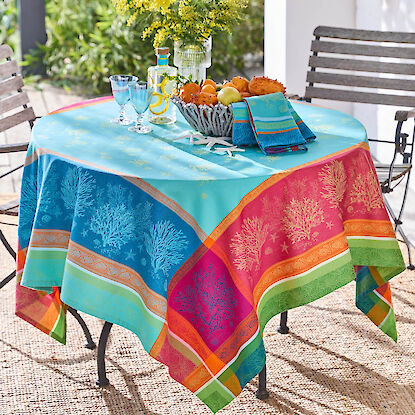 Bunter Gartentisch mit dekorativer Tischdecke, Getr&auml;nken, Obstschale und Blumenstrau&szlig;