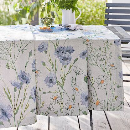Tisch mit floraler Tischdecke aus Leinen, Wiesenblumen-Motiv in Blau und Wei&szlig; auf sonniger Terrasse