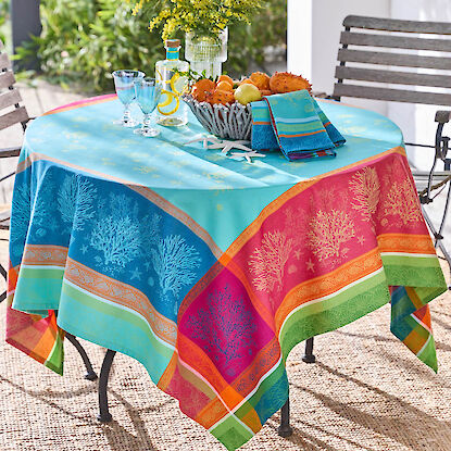 Bunter Tisch mit gemusterter Tischdecke, dekoriert mit Gl&auml;sern, Obstschale und Blumen auf Terrasse