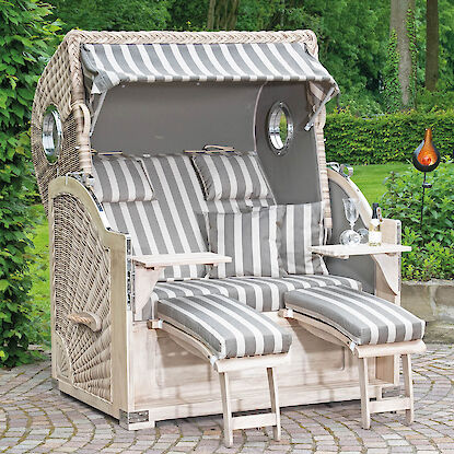 Strandkorb aus Holz mit grau gestreiften Polstern und Fu&szlig;st&uuml;tzen im Garten auf Terrasse