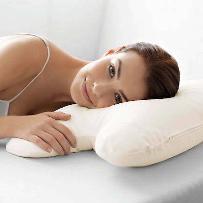 Ergonomisches Nackenst&uuml;tzkissen in Wei&szlig;, genutzt von einer entspannt liegenden Frau