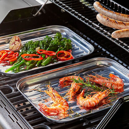 Edelstahl Grillschalen mit Grillgut auf einem Grillrost