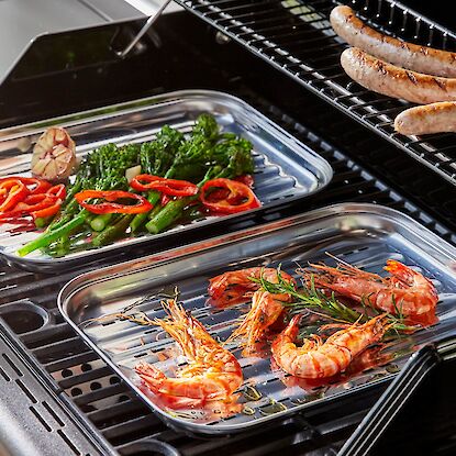 Plats de cuisson inox avec crevettes, l&eacute;gumes et saucisses sur barbecue &agrave; gaz