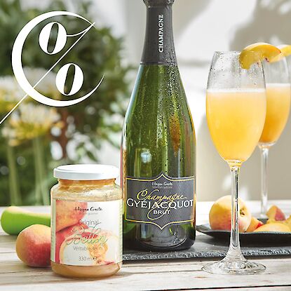 Bellini mit Pfirsich und Champagner, zwei Gl&auml;ser und Flasche, daneben Bellini-P&uuml;ree im Glas und frische Pfirsiche