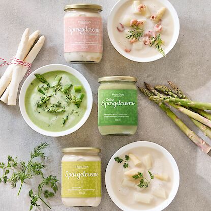 Spargelcremes in Gl&auml;sern und Schalen, wei&szlig;e und gr&uuml;ne Varianten mit Spargelst&uuml;cken und Kr&auml;utern dekoriert