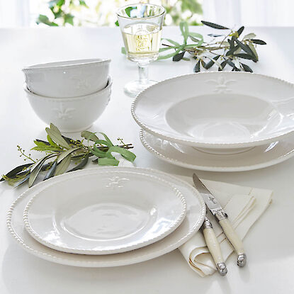 Service de table blanc avec assiettes creuses, bols et couverts sur table dress&eacute;e