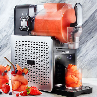 Slush-Eis-Maschine mit fruchtigem Sorbet, serviert in Gl&auml;sern mit frischen Beeren