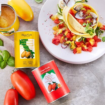 Konservierte Tomaten aus Italien mit kreativ angerichteter Pasta und frischen Zutaten