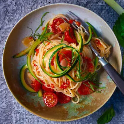 Spaghetti mit Zucchini, Tomaten und Kr&auml;utern auf Teller angerichtet, leichtes mediterranes Pastagericht