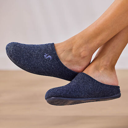 Bequeme Hausschuhe aus Filz in Dunkelblau mit rutschfester Sohle, getragen barfu&szlig; in Innenraum
