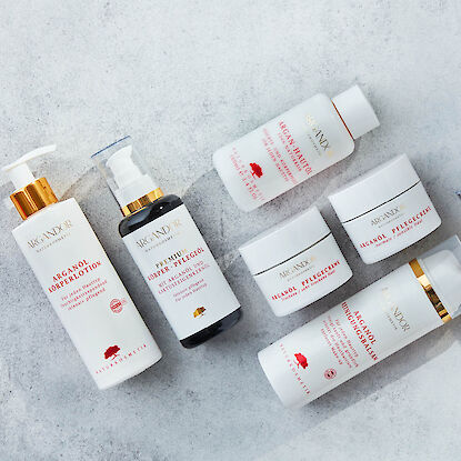 Kosmetikset mit Argan&ouml;l-Produkten wie Lotion, Creme und Reinigung, minimalistisch auf hellem Untergrund arrangiert