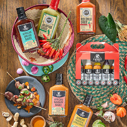 Diff&eacute;rentes sauces piquantes avec piment, jalape&ntilde;o et &eacute;pices, pr&eacute;sent&eacute;es avec ingr&eacute;dients et brochettes sur table en bois