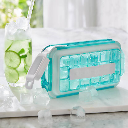 Bac &agrave; gla&ccedil;ons avec couvercle et gla&ccedil;ons, &agrave; c&ocirc;t&eacute; un verre avec citron vert, menthe et glace pour boisson rafra&icirc;chissante