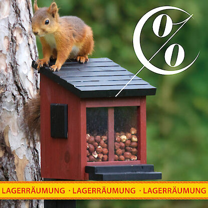 Rabattiertes Eichh&ouml;rnchen-Futterhaus mit N&uuml;ssen im Garten bei naturnaher Lagerr&auml;umung