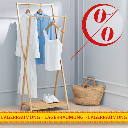 Rabattierter Kleiderst&auml;nder mit sommerlicher Damenbekleidung und Korbtasche bei Lagerr&auml;umung