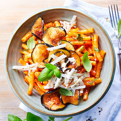 Plat de pâtes siciliennes garnies d'aubergines grillées, de sauce tomate et de fromage râpé.