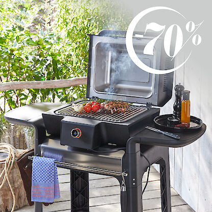 Grill avec légumes et viande, en arrière-plan une véranda en bois. À droite, il est écrit "-70%".