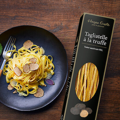 Tagliatelles à la truffe à côté d'une assiette de tagliatelles cuites.