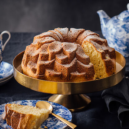 Un gâteau fraîchement cuit sur un plat à gâteau doré.