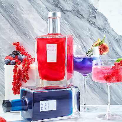 Bouteilles 'Pink Velvet' et 'Blue Velvet', entourées de cocktails garnis de baies