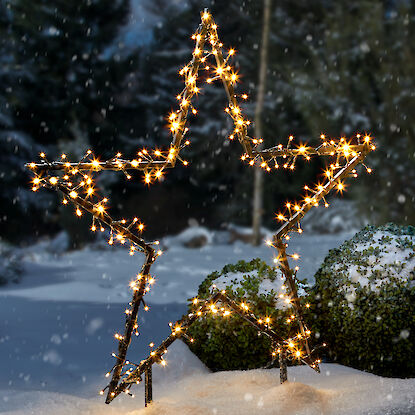 Leuchtender Stern aus Lichterketten im Schnee