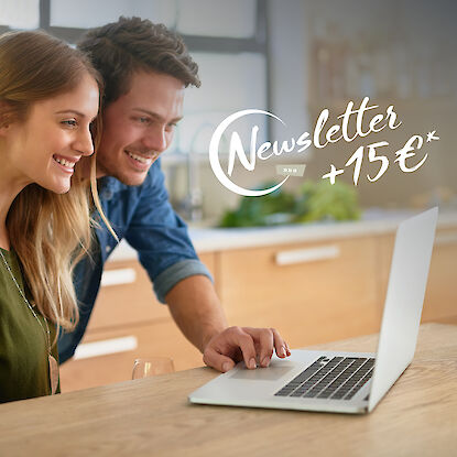 Personen stehen vor einem Laptop in der Küche, eechts im Bild steht der Schriftzug Newsletter +15 €