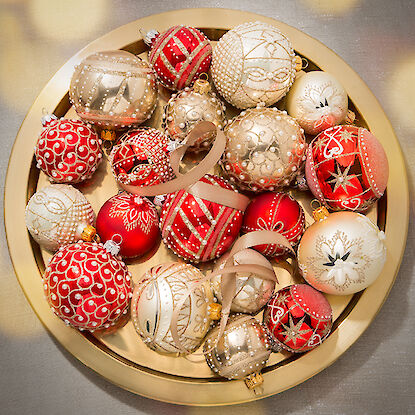 Rote und goldene Weihnachtsbaumkugeln mit aufwendigen Verzierungen