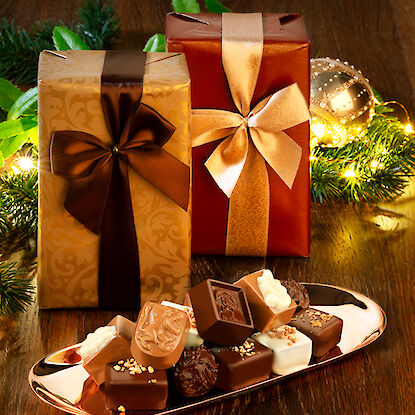 Cadeaux emballés de façon festive avec des pralines et des décorations de Noël.