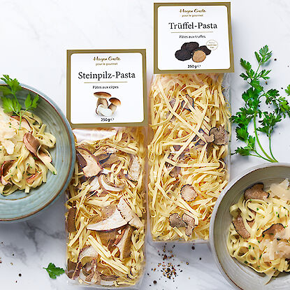 Steinpilz- und Trüffel-Pasta mit frischen Kräutern dekoriert.