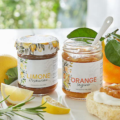 Gläser mit Zitronen-Rosmarin und Orangen-Ingwer Marmelade, dekoriert mit frischen Früchten