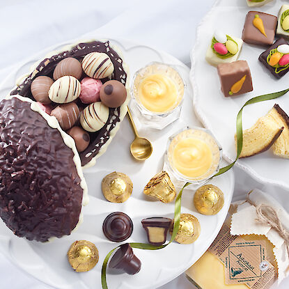 Table de Pâques avec œuf en chocolat, pralines et gâteau à étages