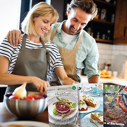 Lächelndes Paar beim gemeinsamen Kochen in der Küche.