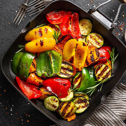 Légumes grillés avec poivrons, courgettes et patates douces dans une poêle grill avec herbes