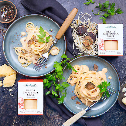 Spaghetti à la sauce truffe, gorgonzola et cacio e pepe, servies avec des truffes fraîches.