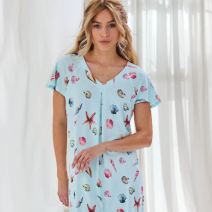 Frau in hellblauem Nachtkleid mit bunten Muschel
