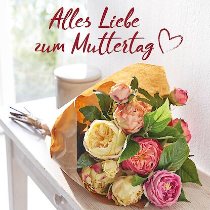 Blumenstrauß mit Rosen auf Holztisch neben Schriftzug ‚Alles Liebe zum Muttertag‘ mit Herzsymbol