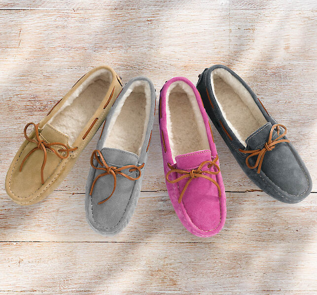 Vier Paar Mokassins mit Schleife und Lammfellfutter in Beige, Grau, Pink und Dunkelgrün