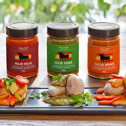 Drei spanische BBQ-Saucen mit Mojo Rojo, Mojo Verde und Salsa Brava, serviert mit Kartoffeln und Gemüse.