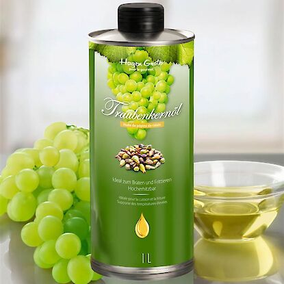 Flasche Hagen Grote Traubenkernöl mit Weintrauben und Ölglas im Hintergrund.