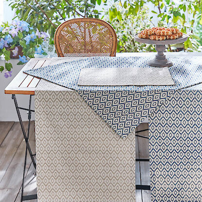 Tischwäsche mit Rautenmuster auf Gartentisch, dekoriert mit Gebäck.