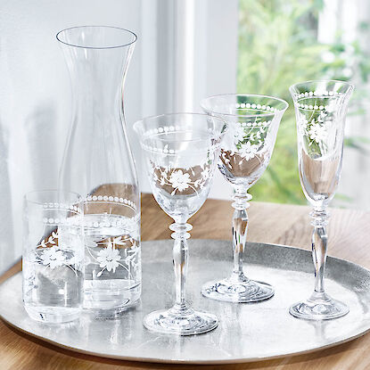 Karaffe und Gläser aus graviertem Kristallglas mit Blumenmotiv auf Silbertablett.