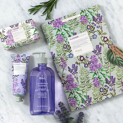 Pflegeset „Lavender Garden“ mit Seife, Handcreme und Schubladenpapier auf Marmorfläche.