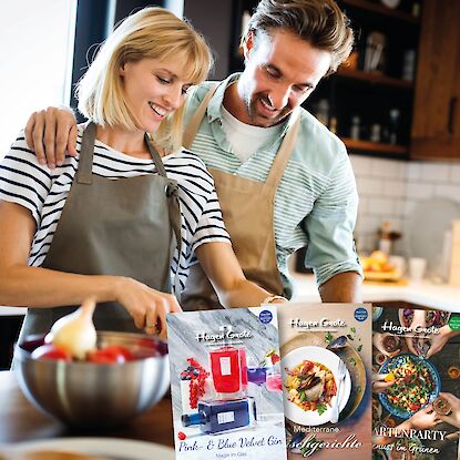 Lächelndes Paar beim gemeinsamen Kochen in der Küche.