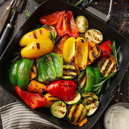 Gegrilltes Gemüse in Grillpfanne mit Paprika, Zucchini, Süßkartoffel und Rosmarin.