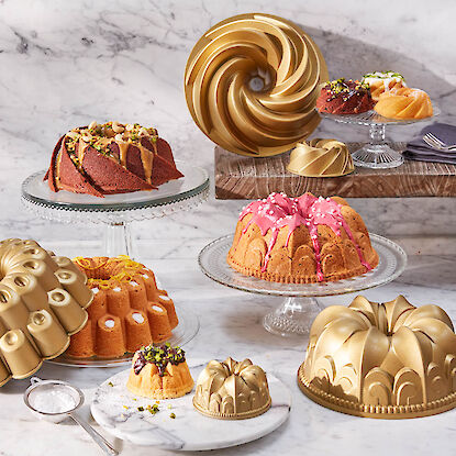 Différents gâteaux kouglof sur des plateaux en verre et moules à gâteau dorés