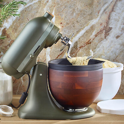 Robot de cuisine KitchenAid avec bol en noyer pétrit une pâte à pain sur le plan de travail